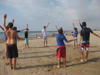 chicos calentando en la arena de la playa